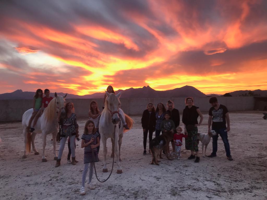 Grupo reunido en el rancho al atardecer
